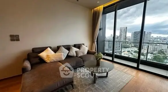 Modern living room with city view and stylish furniture in high-rise apartment.