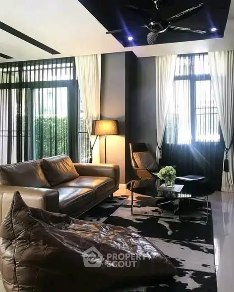 Stylish modern living room with leather sofa, chic decor, and ample natural light.