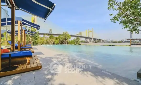 Luxurious poolside view with modern loungers and scenic bridge backdrop.