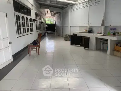 Spacious tiled corridor with open kitchen area and natural light, ideal for versatile use.
