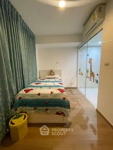 Cozy bedroom with wooden flooring, modern air conditioning unit, and large window with whimsical curtain design, perfect for restful nights.