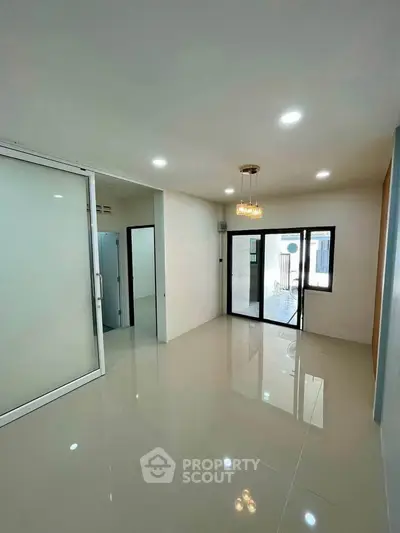 Spacious modern living room with glossy tile flooring and elegant lighting