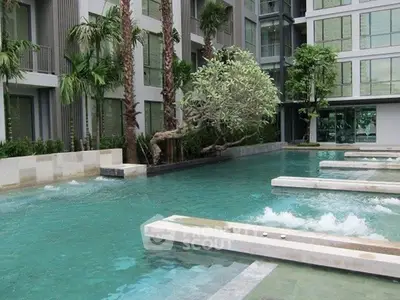 Luxurious condominium pool area with modern design and lush greenery