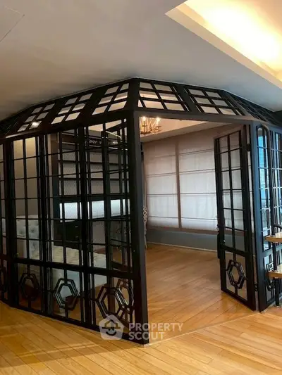 Elegant interior with glass partition and wooden flooring in a modern living space.