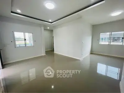 Spacious modern living room with large windows and sleek ceiling design