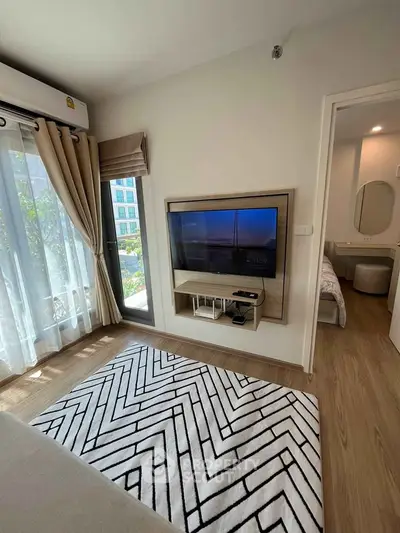 Modern living room with stylish decor and wall-mounted TV in a bright apartment.