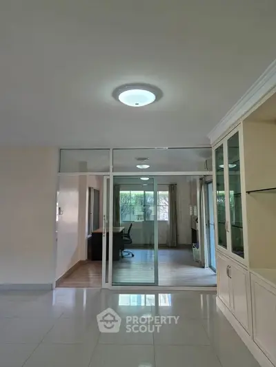 Spacious modern living room with glass partition and built-in cabinets