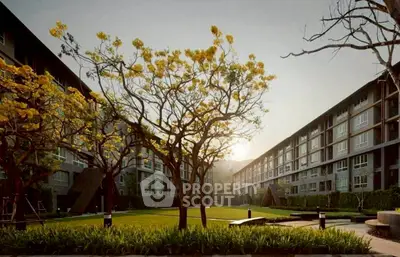 Stunning residential complex with lush garden and modern architecture at sunset.