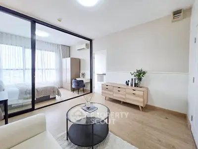 Modern living room with glass partition and cozy bedroom view