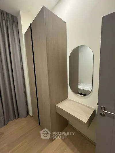 Modern bedroom with sleek wardrobe and stylish mirror, perfect for contemporary living.