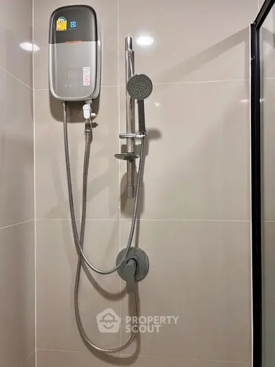 Modern bathroom shower with sleek design and water heater in contemporary home.