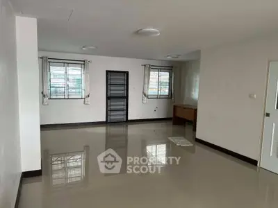 Spacious empty living room with tiled flooring and large windows