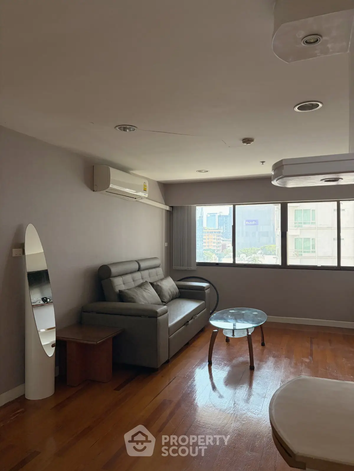 Spacious living room with modern sofa and city view, perfect for urban living.