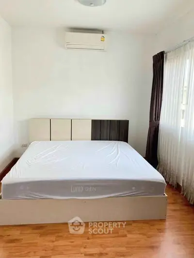 Spacious bedroom with large bed and natural light from window