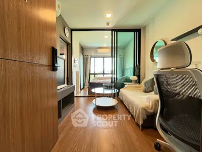 Modern studio apartment with stylish furnishings and wooden flooring, featuring a cozy living area and bedroom.