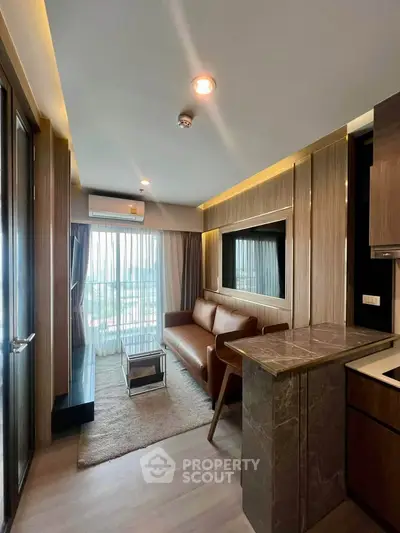 Modern living room with stylish decor and large window offering natural light and city view.