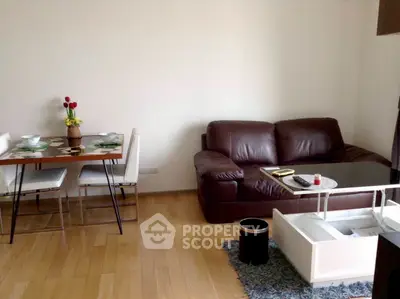 Cozy living room with leather sofa and dining area, perfect for relaxation.