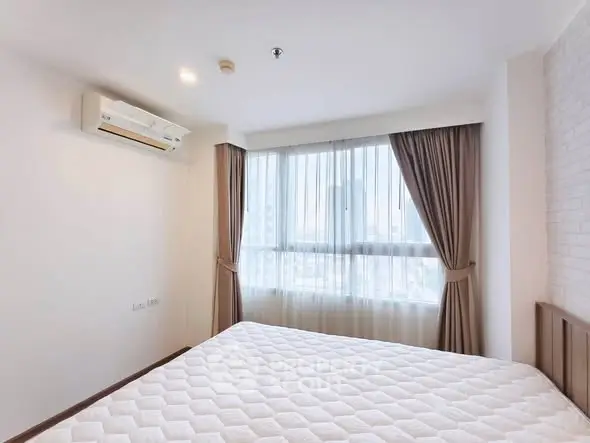 Bright and airy bedroom with large window and modern air conditioning unit.