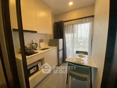 Modern kitchen with dining area and balcony view in a cozy apartment.