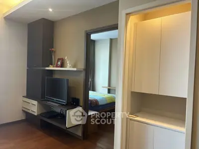 Modern apartment interior with cozy living room and bedroom view, featuring sleek furniture and warm lighting.