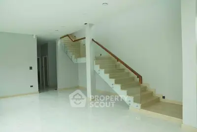 Spacious modern interior with elegant staircase and glossy flooring