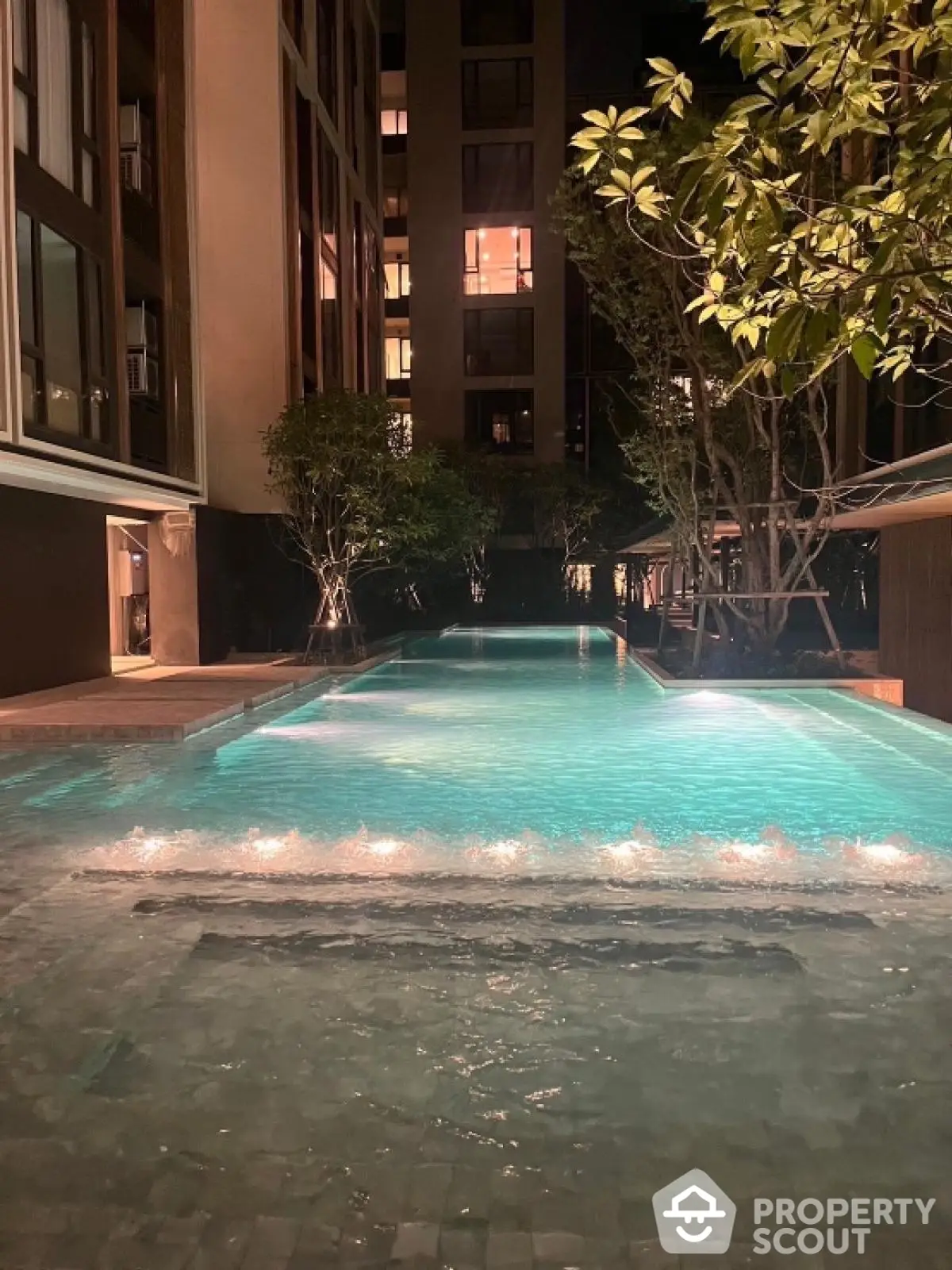 Luxurious night view of illuminated swimming pool in modern residential complex