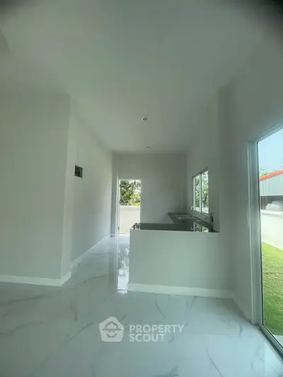 Spacious modern kitchen with sleek design and large windows for natural light.