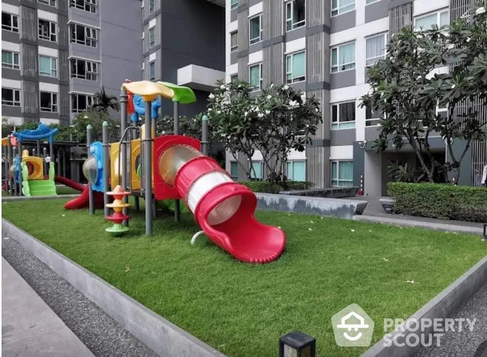 Modern apartment building with colorful playground and lush greenery