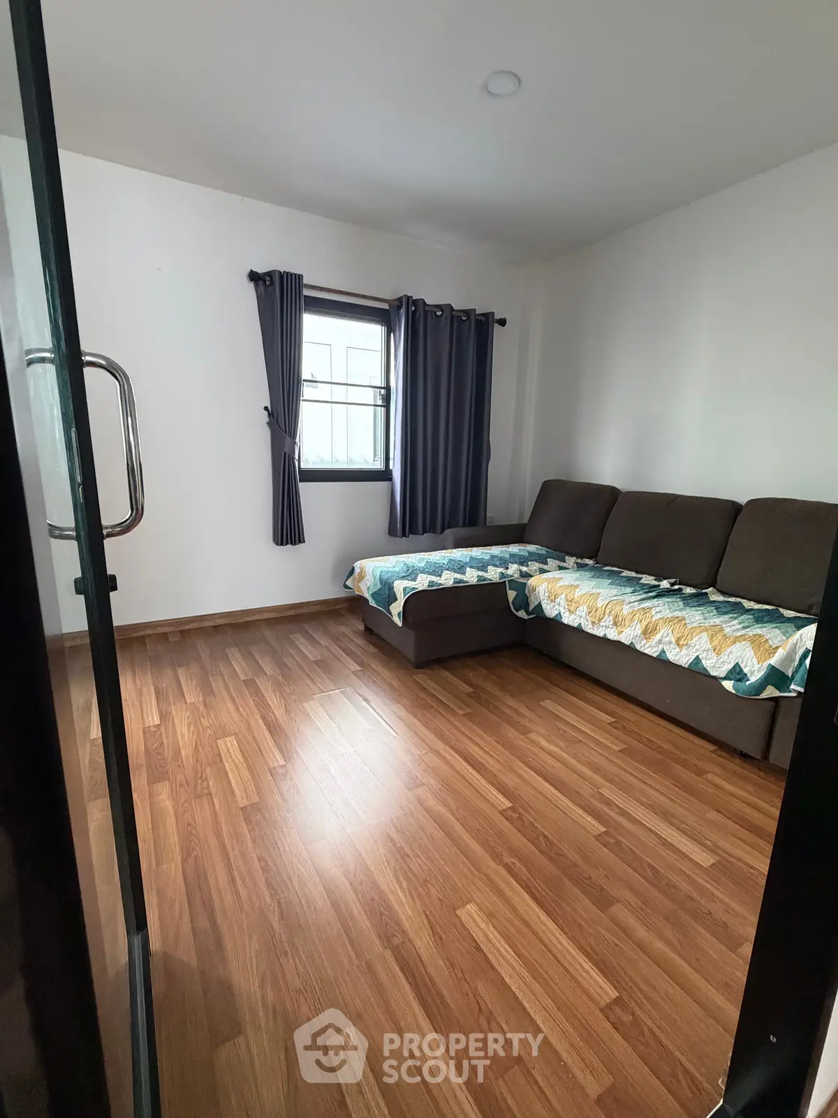 Cozy living room with wooden flooring and modern sofa, perfect for relaxation.