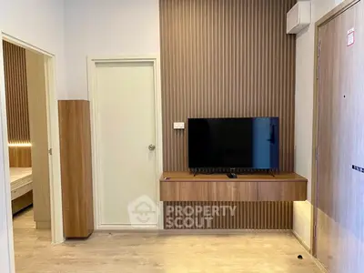 Modern living room with sleek wooden accents and wall-mounted TV, showcasing minimalist design.