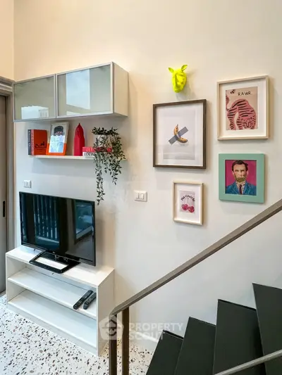 Stylish living room with modern decor and wall art, featuring a sleek TV setup.
