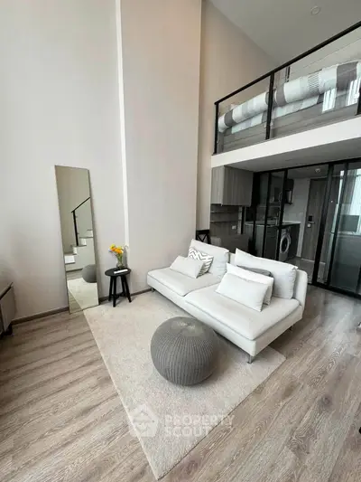 Modern loft apartment with stylish living room and mezzanine, featuring sleek furniture and open layout.