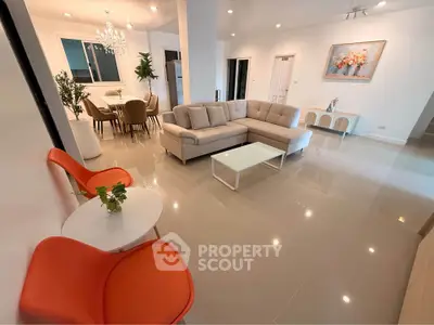 Spacious modern living room with elegant decor and open dining area, perfect for entertaining.