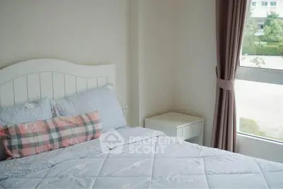 Cozy bedroom with large window and stylish bedding in modern apartment