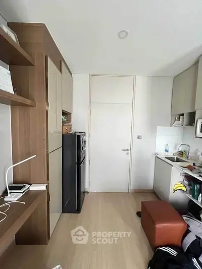 Compact modern kitchen with sleek cabinetry and integrated appliances in a cozy apartment.