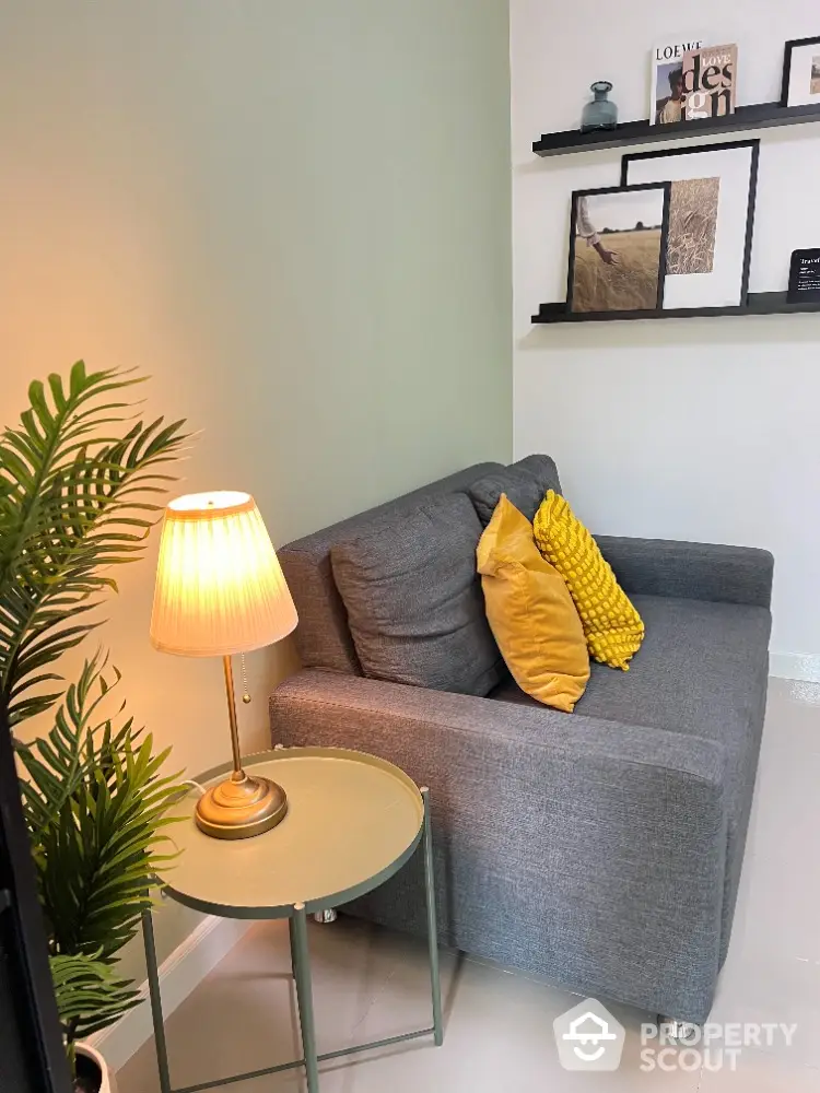 Cozy living room with stylish gray sofa and decorative pillows, perfect for relaxation.