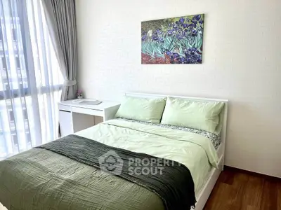 Bright bedroom with modern decor and large window, featuring a stylish bed and artwork on the wall.