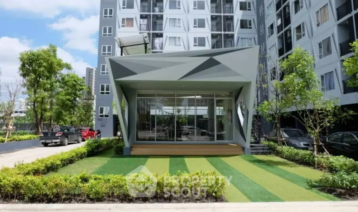 Modern apartment building with unique geometric entrance and landscaped garden