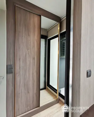 Modern closet with sliding mirrored doors in a stylish interior space.