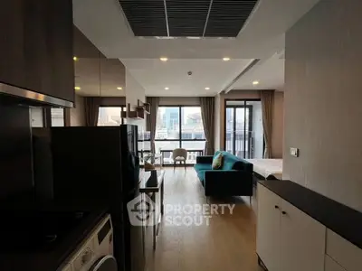 Modern open-plan apartment with city view, featuring sleek kitchen and cozy living area.