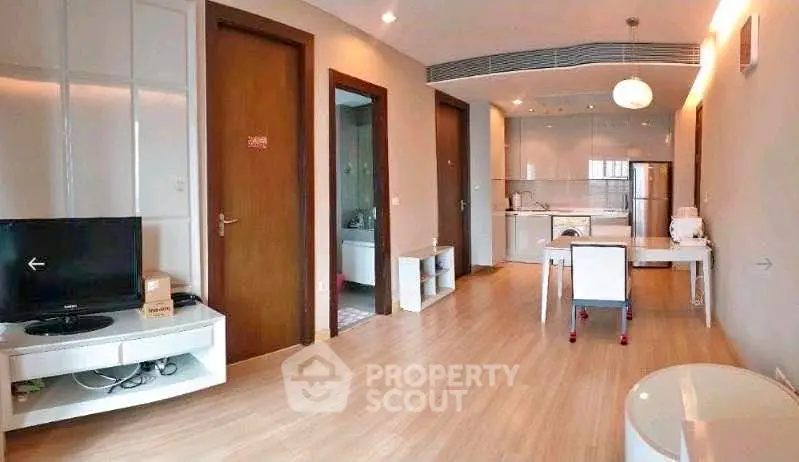 Modern open-plan living room with sleek kitchen and wooden flooring