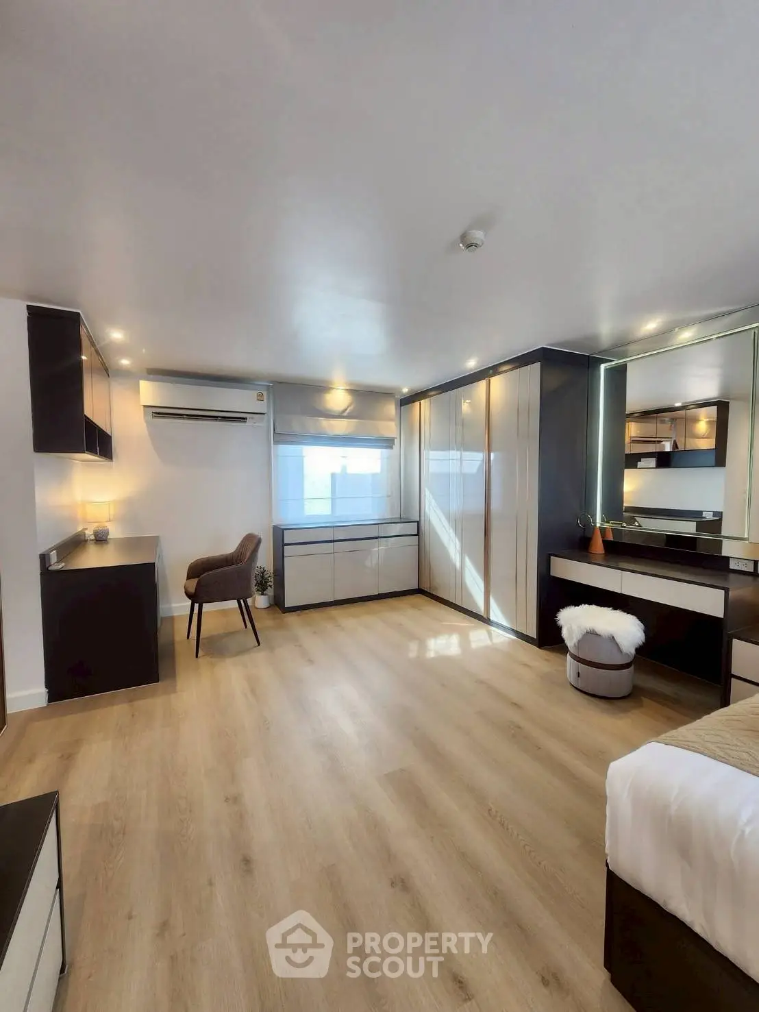 Spacious modern bedroom with elegant furnishings and ample natural light