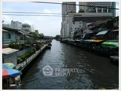 Scenic canal view with urban buildings and waterfront homes, ideal for real estate investment.