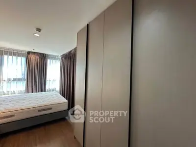 Spacious bedroom with large windows and modern design in a luxury apartment.