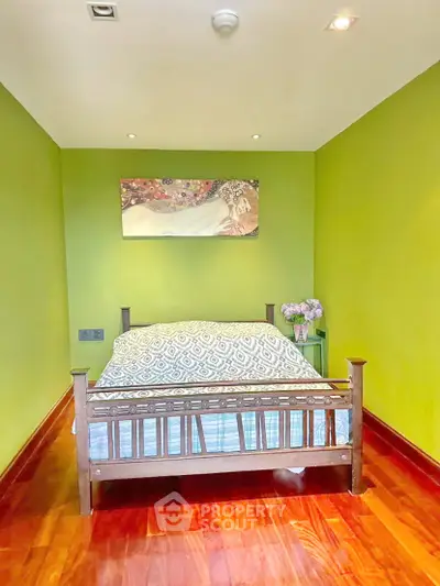Charming bedroom with vibrant green walls and elegant wooden bed frame