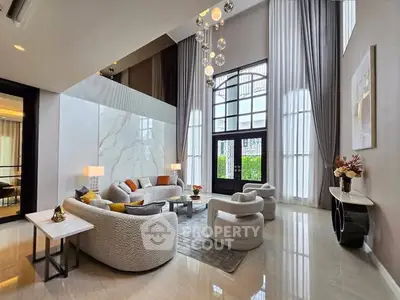 Luxurious high-ceiling living room with elegant decor and large windows