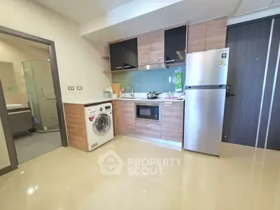 Modern kitchen with sleek appliances and washing machine in stylish apartment.