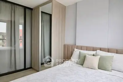 Modern bedroom with stylish decor and large window for natural light.