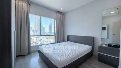 Modern bedroom with city view, featuring a sleek bed and large window in a high-rise apartment.