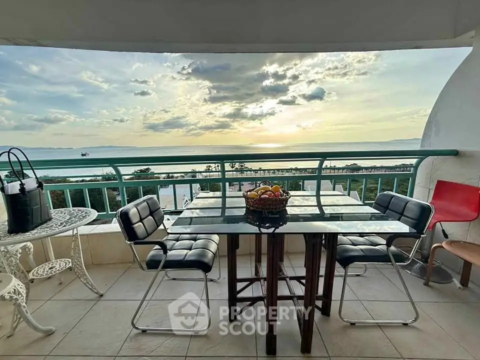 Stunning balcony with ocean view, modern furniture, and sunset ambiance.